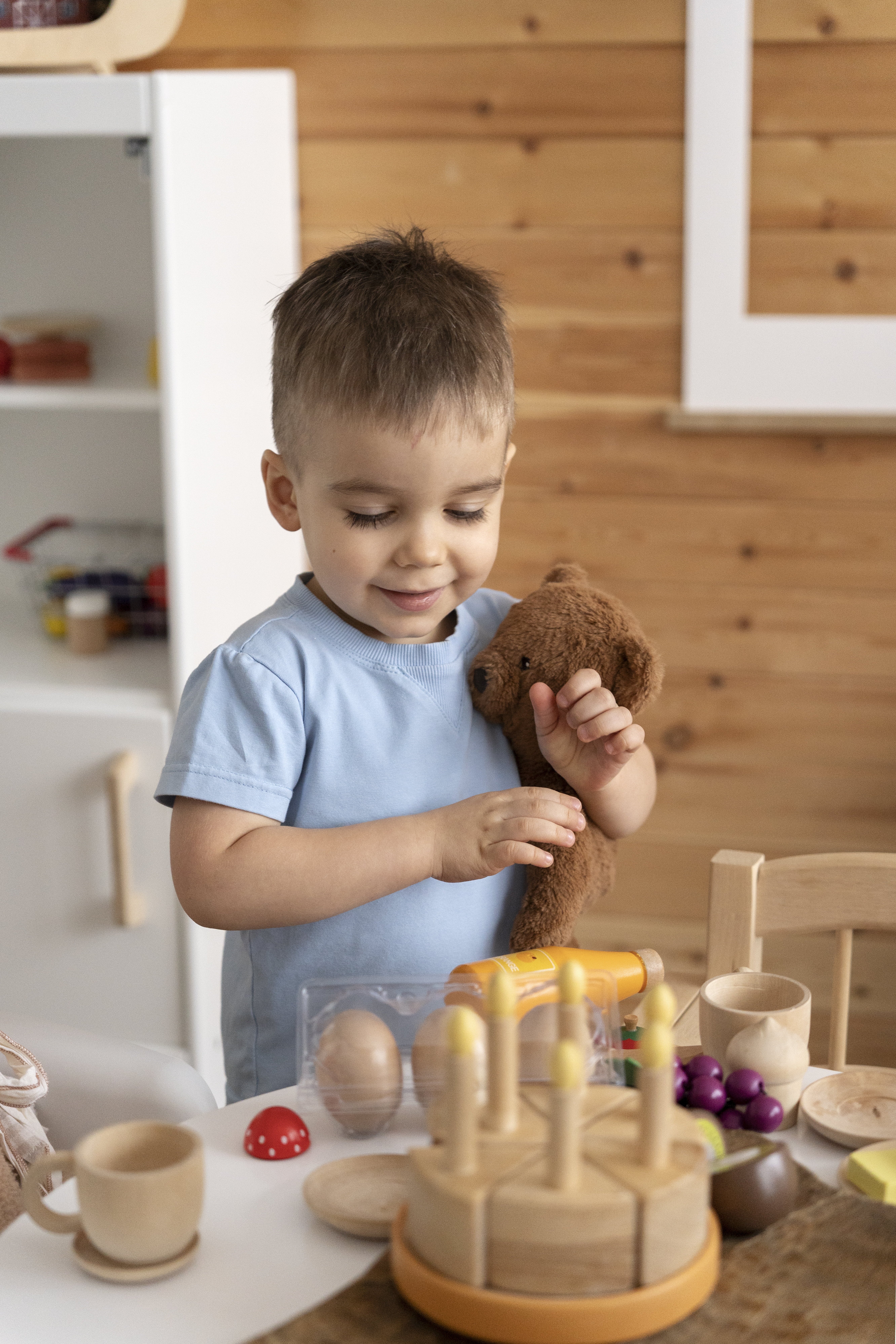 A toddler playing with a set of curated wooden toys from a Whirl activity kit